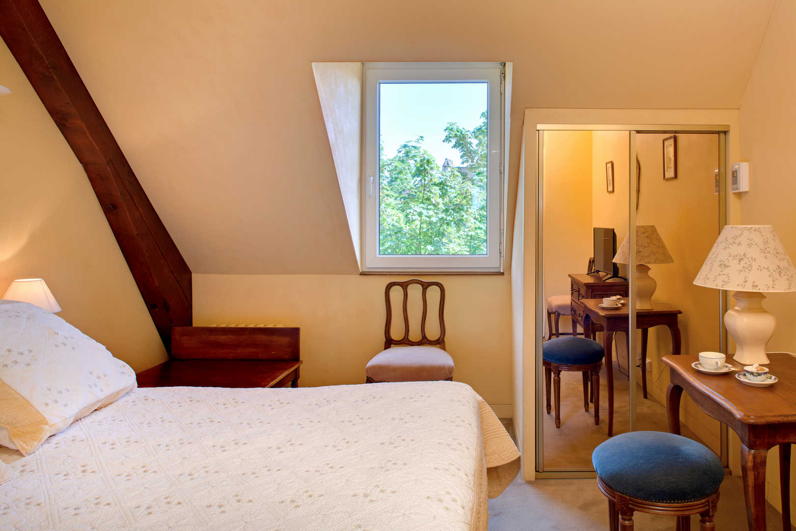 Vue paysage de l'intérieure d'une chambre confortable dans l'hôtel de charme L'Esplanade, en Dordogne