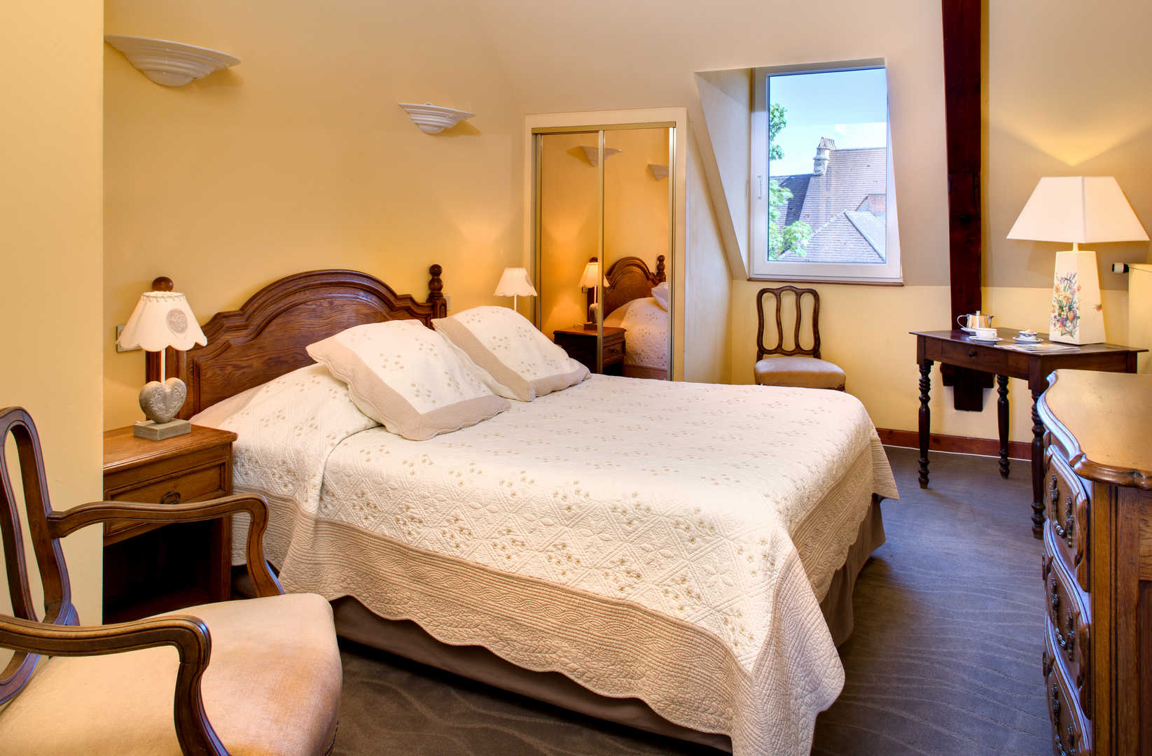 Vue d'une chambre avec parure de lit blanche dans l'hôtel de charme en Dordogne, l'Esplanade