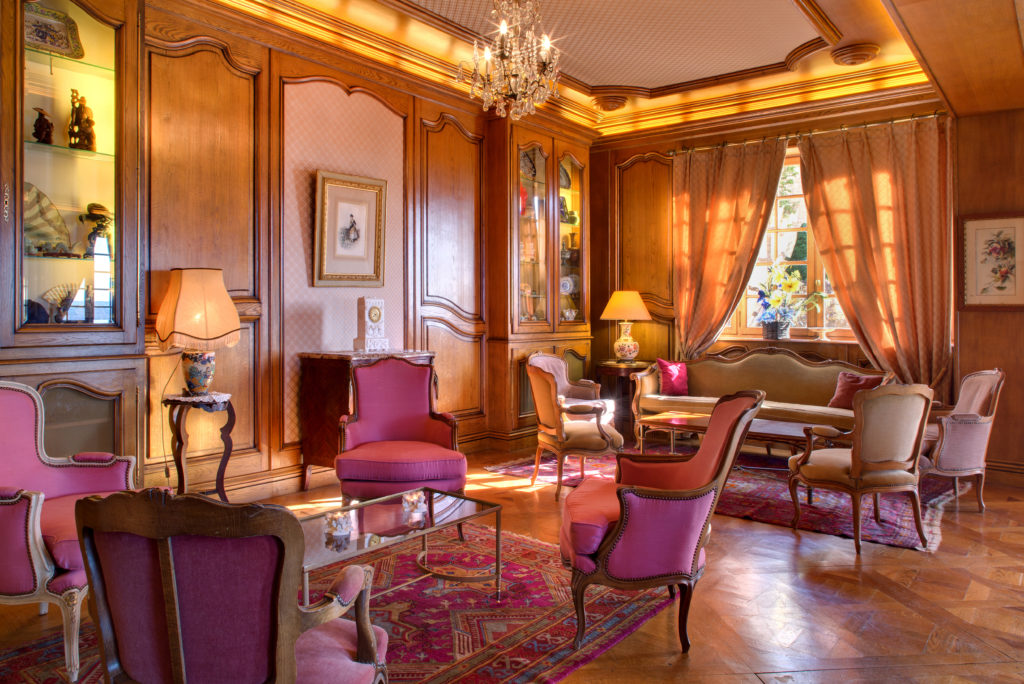 Vue intérieure sur un salon au fauteuils roses dans l'hôtel l'Esplanade, restaurant à Domme.